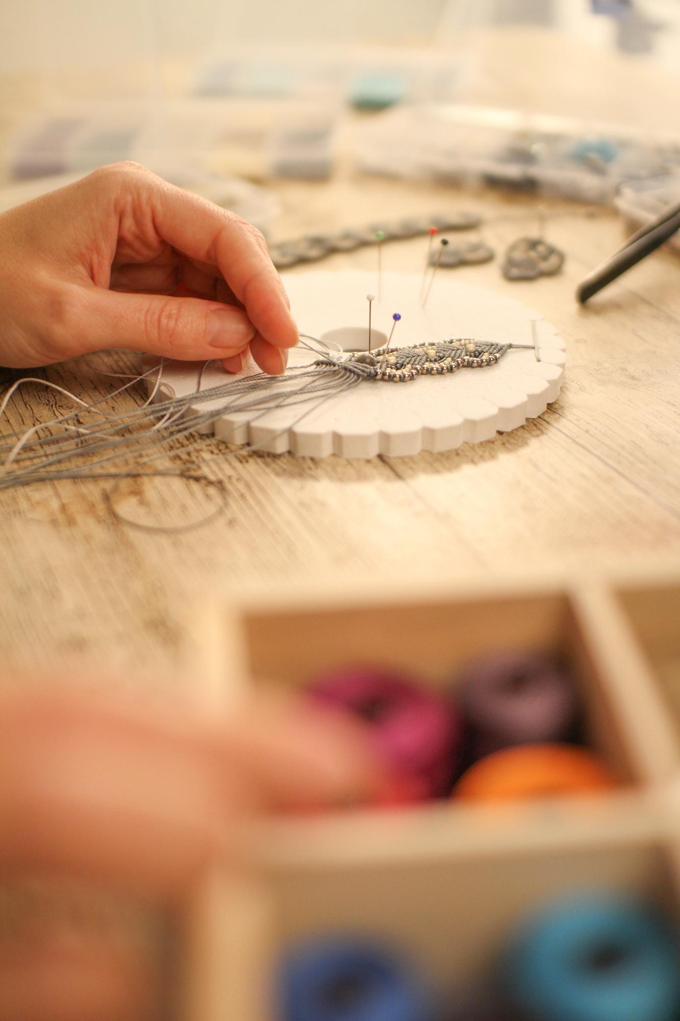 Artisan hands selecting threads in a studio